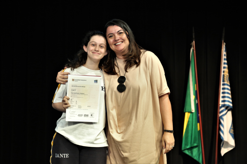 Professora Milena Carmona entrega certificado do exame de Cambridge à aluna do Dante